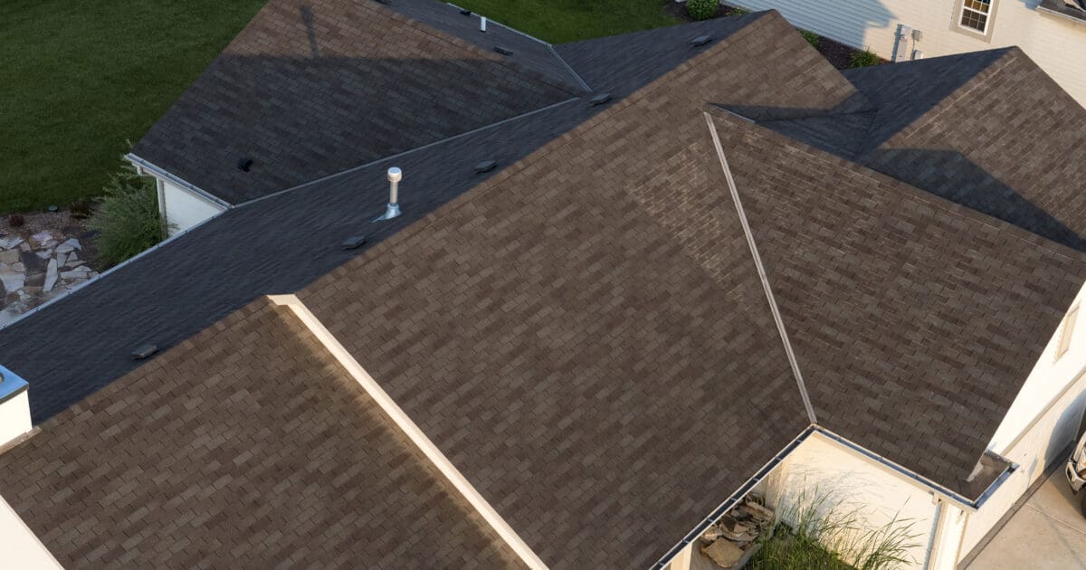 Aerial view of a home with a brown architectural shingle roof